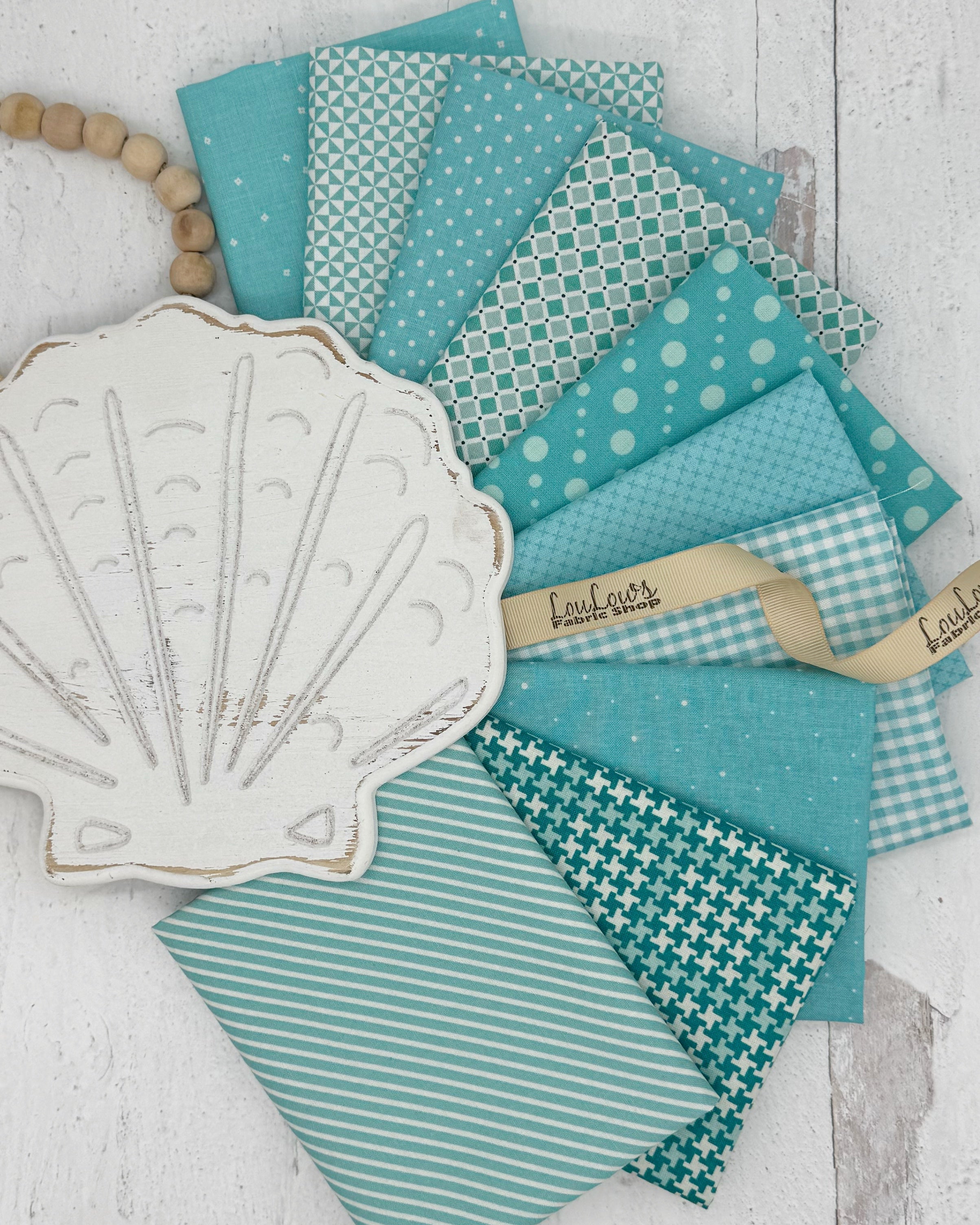 10 aqua and soft teal fat quarters in geometric and gingham prints. 