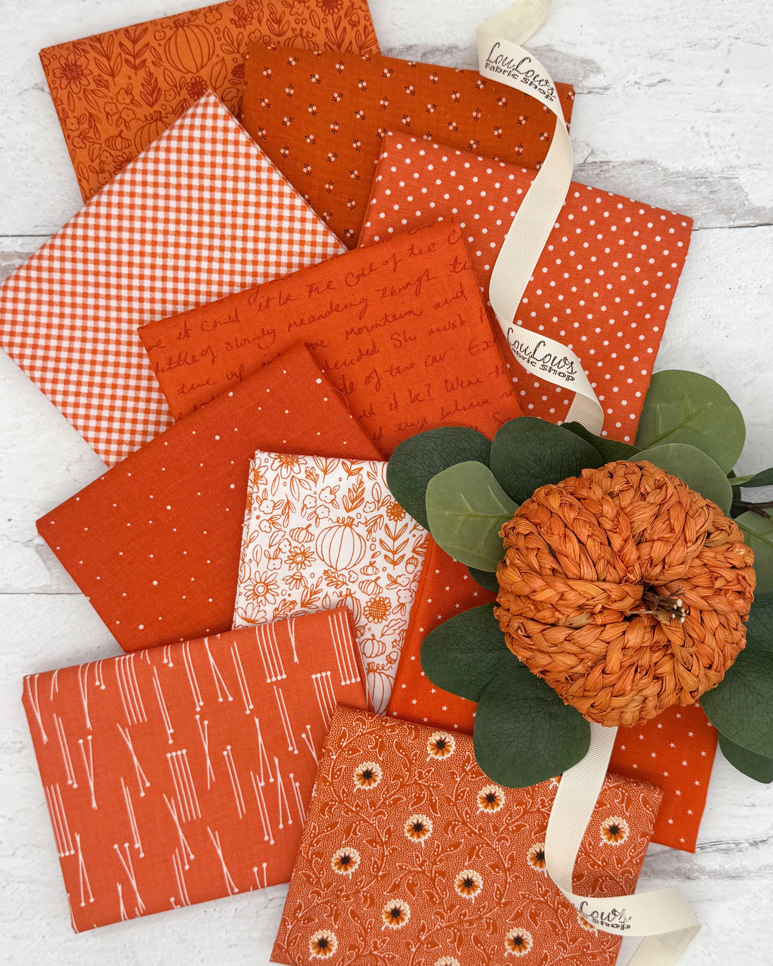 10 fat quarters in various shades of pumpkin oranges. Prints include floral, sketch, ginghams and dot prints. 