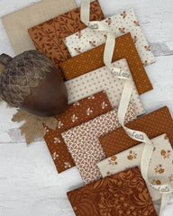 10 fat quarters, 5 with a cinnamon colored background, 5 with off white background. Prints include acorns, dots and florals. 