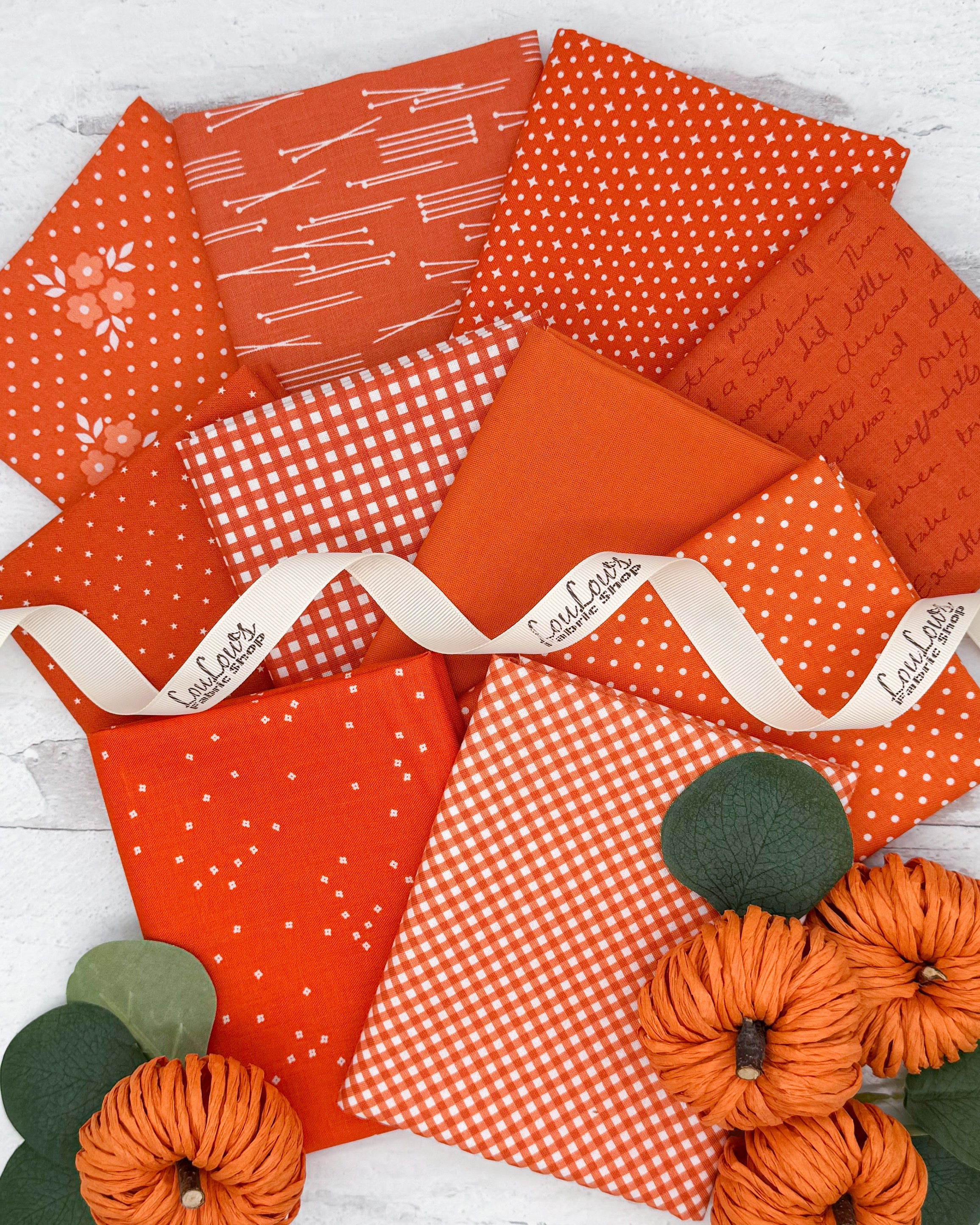 10 bright true orange fat quarters with dot, star, gingham and floral prints. 